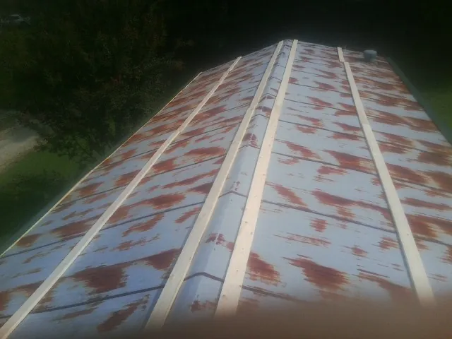 Rusted metal roof panels with new wood purlins before replacement — Storm Damage Roof Repair in Adelphi by Roofing Brothers